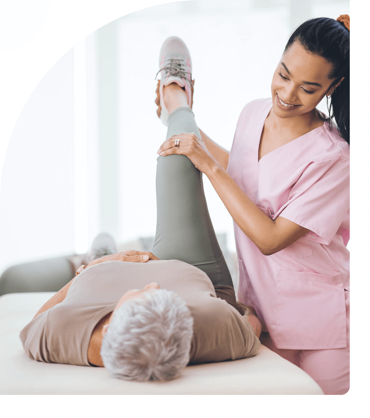 Therapist assisting patient with leg exercise.