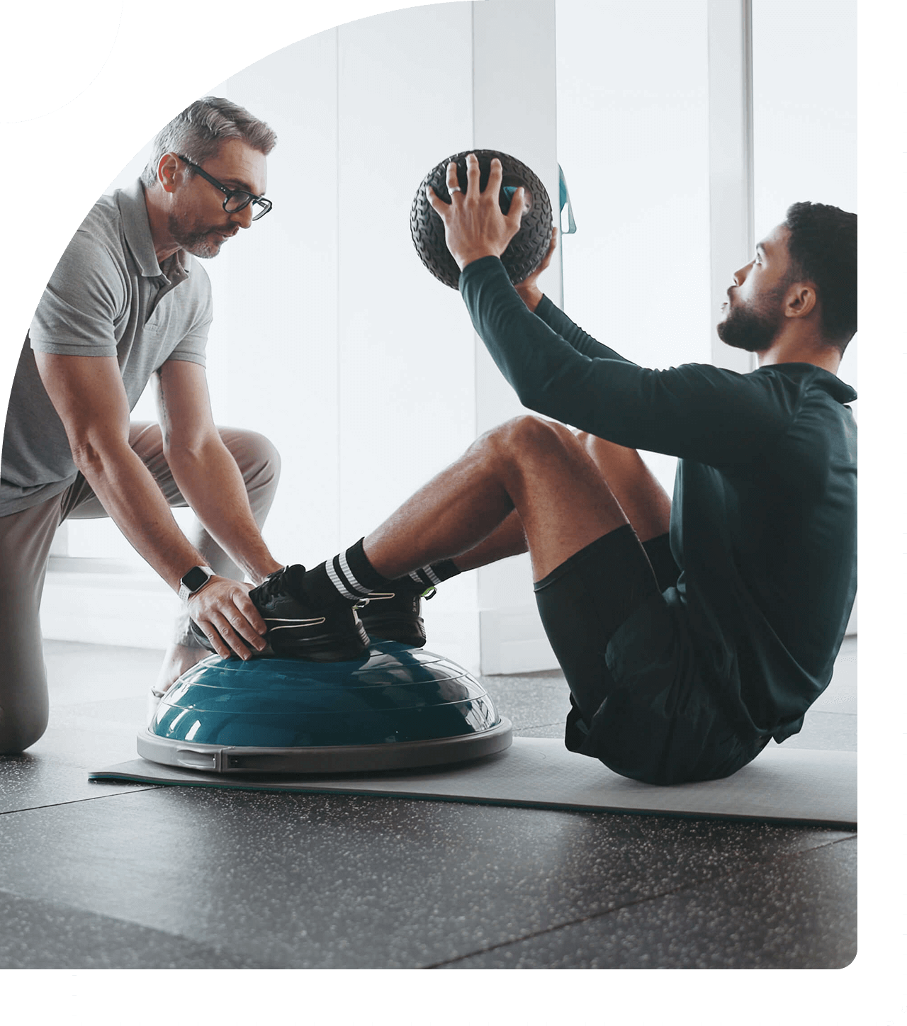 Man doing sit-ups with trainer's assistance.