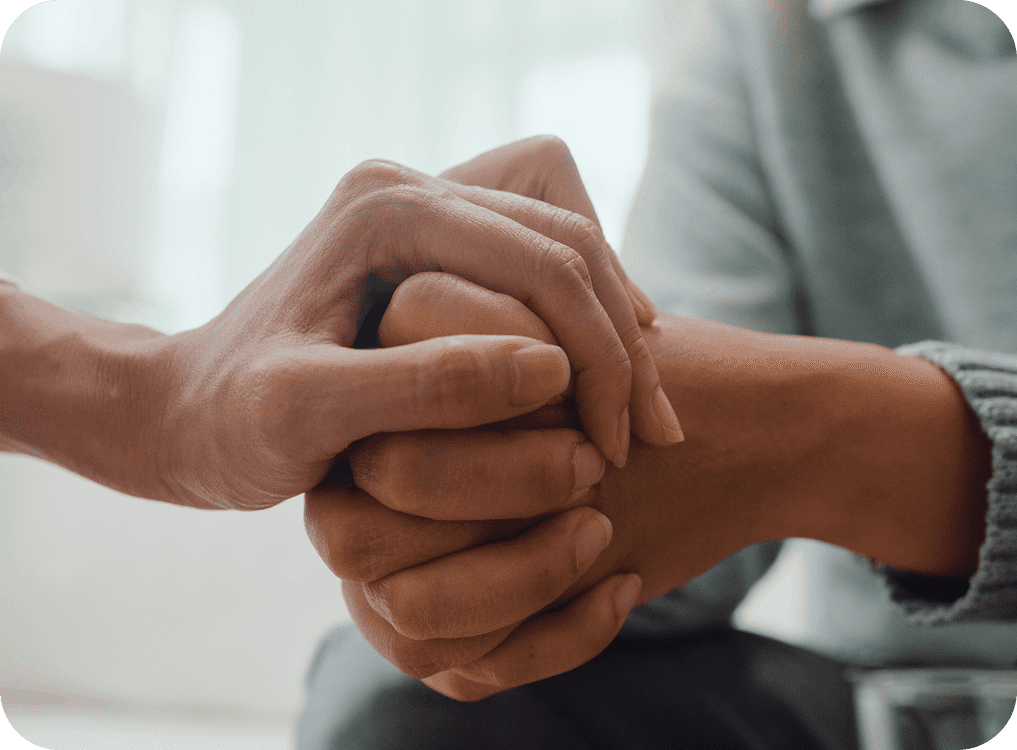 Two people holding hands in support.