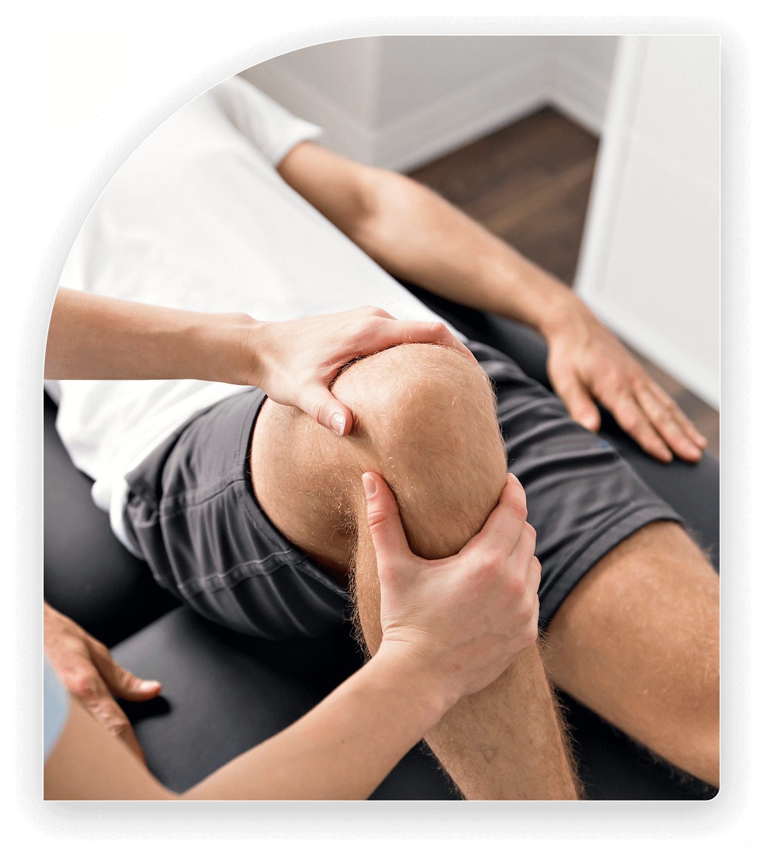 Therapist examining patient's knee on table.